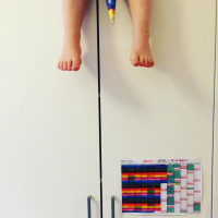 Tochter spielt auf dem Schrank mit der Schult&uuml;te des Bruders. Unten h&auml;ngt ihr Schul-Countdown-Kalend